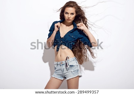Beautiful young woman in jeans shirt and shorts. Summer fashion photo. Very long healthy hair