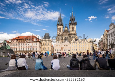 PRAGUE, CZECH REPUBLIC - JUNE 15, 2014: Tourists sitting on the floor at the Old Square in Prague. Old Town Square is a historic square in the Old Town quarter of Prague.