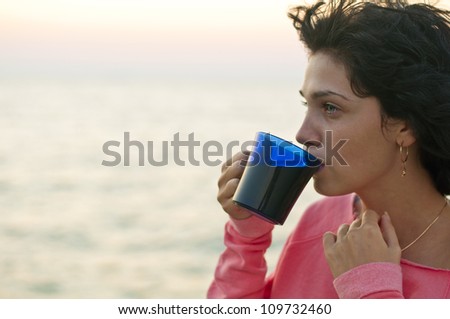 drinks tea near the sea