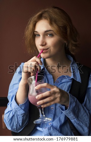 young woman drinks smoothie at the cafe