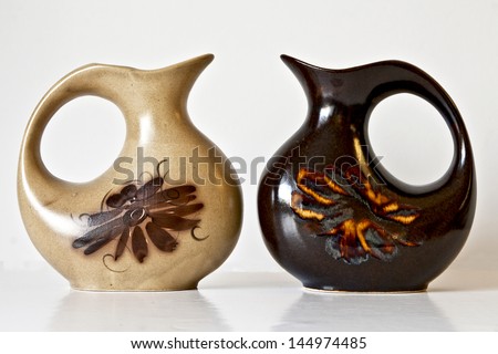 Israeli ceramic pair in  brown tones: two vases of 1950-th years with abstract carved and glazed images.Symbolizes couple: He and She; brother and sister etc. Isolated on white.