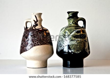 Israeli ceramic pair in black and brown tones: two vases of 1950-th  with abstract carved and glazed images.Symbolizes couple: He and She; brother and sister, bride and groom etc. Isolated on white.