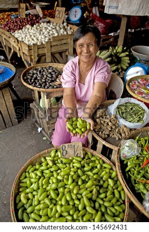 LEGAZPI, PHILIPPINES - NOVEMBER 17, 2012 - Unidentified Filipino woman selling Cucumber Tree Fruit on November 17, 2012 at Legazpi, Philippines. Averrhoa Bilimbi is used as an herbal medicine.