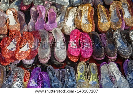 MANILA, PHILIPPINES - APRIL 23, 2012 - Rows of plastic shoes at a street market on April 23, 2012 in Manila, Philippines. Products made from recycled plastics and bottles are imported from China.