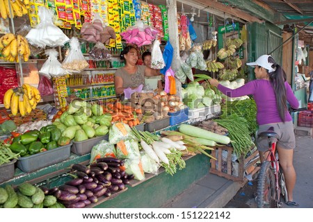 LUZON, PHILIPPINES - CIRCA 2011 - Unidentified market vendor sells fruit from her market stand circa 2011 in Luzon, Philippines. Fresh fruit and vegetables are abundantly available to people.
