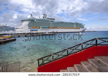 COZUMEL, MEXICO - JANUARY 15, 2015: Luxury cruise liner, Liberty of the Seas, at port with passengers coming and going along the pier.