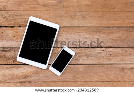 Mobile phone and tablet computer with black screen on old wooden background