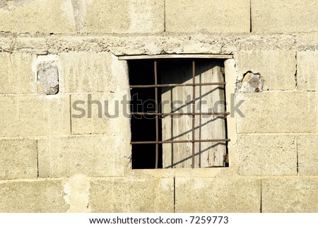 Side of a shed with window with iron grate