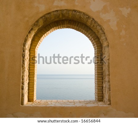 arched window of bricks on the sea