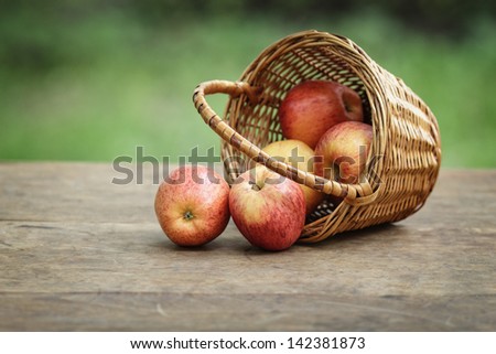 gala apples in a wicker basket, on wooden table