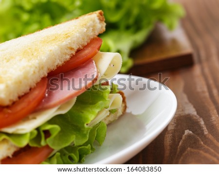 toasted sandwich with ham, cheese and vegetables, on wooden table