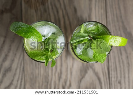two mojito cocktails on old oak table, rustic style