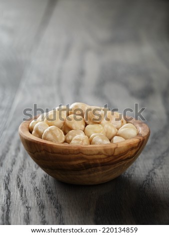 peeled hazelnuts in bowl on old oak table