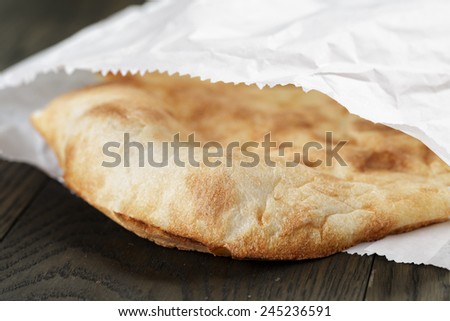 close up of freshly baked flat bread in paper bag