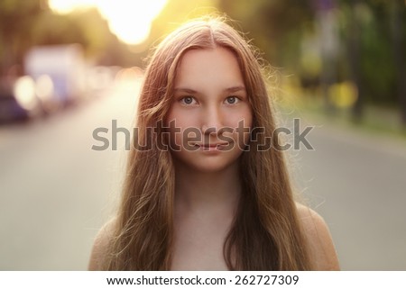 portrait of young teenage girl in town in sunset