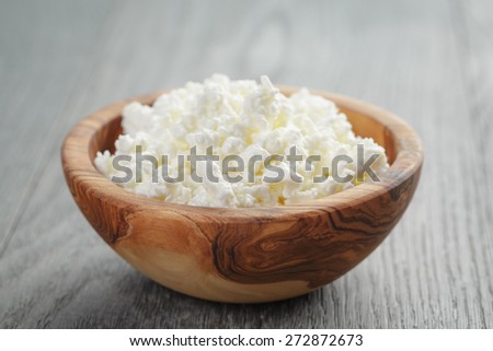 fresh cottage cheese in a wood bowl on a wooden table