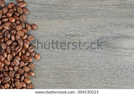 coffee beans border on old oak table, wood background