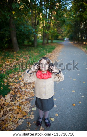 Small girl outdoor in the park hearing nature sounds. Above view