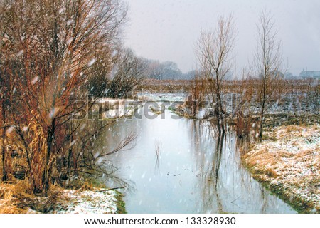 Winter river in snowy weather