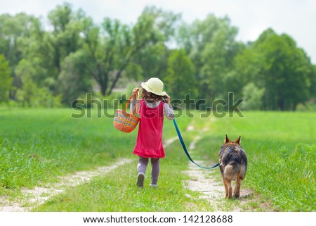 Little girl with dog going on the road to the picnic