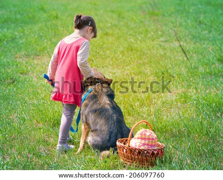 Little girl with dog on picnic back to camera