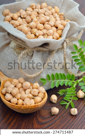 Chickpeas in a burlap bag on a wooden background