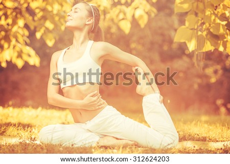 Yoga outdoors in warm autumn sunny park. Concept of healthy lifestyle and relaxation