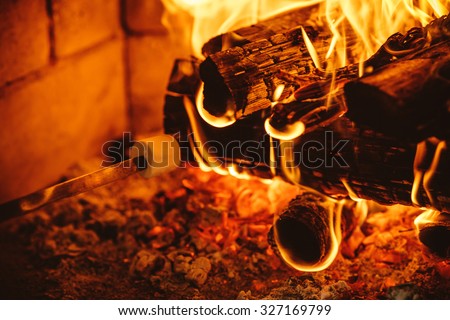 Roasting marshmallows by the fire. Cozy chalet home with fireplace decorated with traditional Christmas ornaments. Cozy relaxed magical atmosphere in a chalet. Holiday concept.