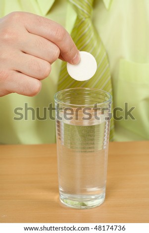Businessman hands near with a glass and an effervescent tablet
