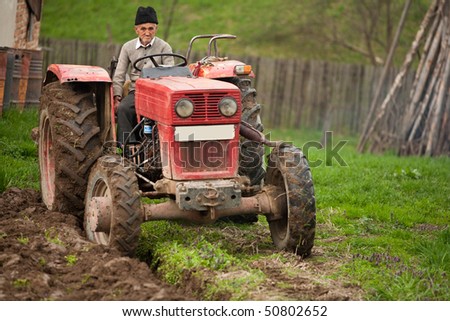 Senior farmer using an old tractor to plow his land