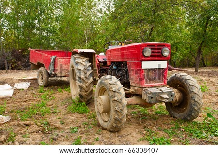 Old tractor and trailer in an orchard