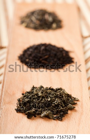 Closeup of three piles with dried leaves tea, of type: jiaogulan, black and green