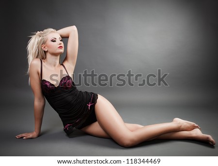 Full length portrait of a beautiful woman wearing lingerie while laying on the floor