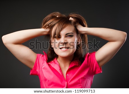 Closeup portrait of an angry woman pulling her hair