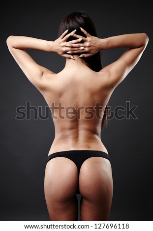 Rear view of hot Arab woman dancing over gray background