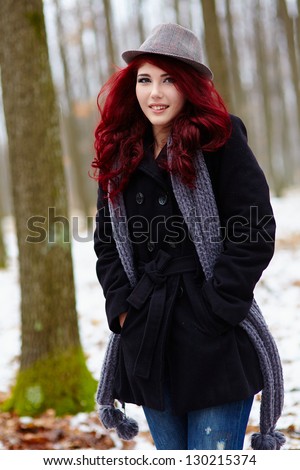 Outdoor closeup of a pretty young woman in a forest, hands in pockets