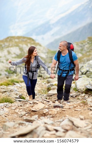 Portrait of a couple holding hands and talking on a mountain trail