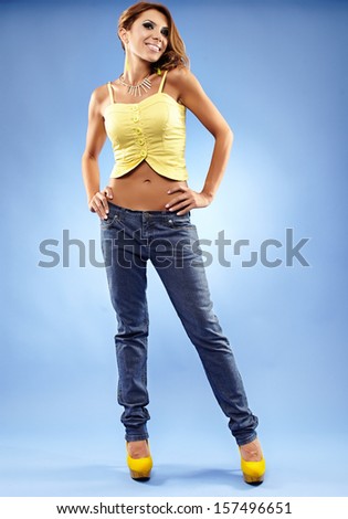 Full length portrait of an attractive woman in jeans, top and high heels
