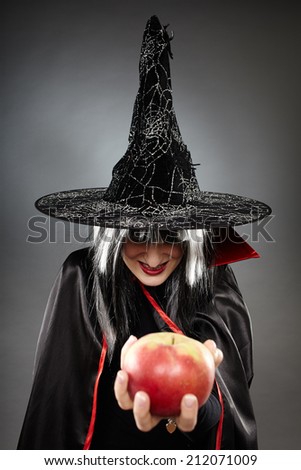 Tricky witch offering a poisoned apple, Halloween theme