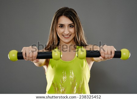 Fitness young woman doing cardio aerobic exercises with light dumbbells