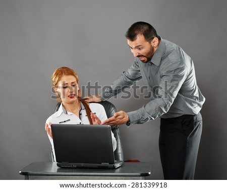 Angry boss shouting at his woman employee over a mistake she did on her laptop