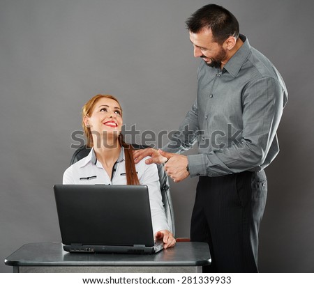 Happy boss impressed with the performance of his female employee, showing thumbs up