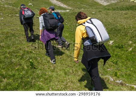 Family of hikers walking on a trail into the mountains