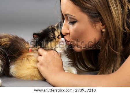 Beautiful young woman kissing a cute persian cat