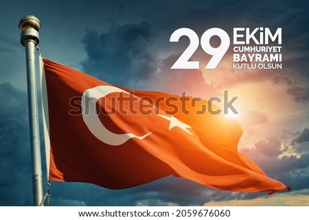 Turkey flag waving in the wind over dramatic cloudy sky during sunrise. "29 Ekim Cumhuriyet Bayrami Kutlu Olsun." Translation: "October 29, Happy Republic Day of Turkey." National holiday of Turkey. 
