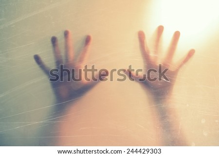 hands behind the frosted glass. fear, panic, scream concept.