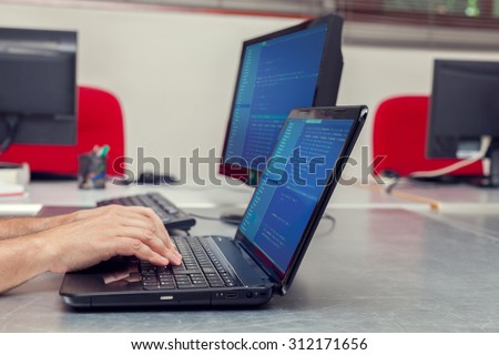 Developer working on source codes on laptop at office.