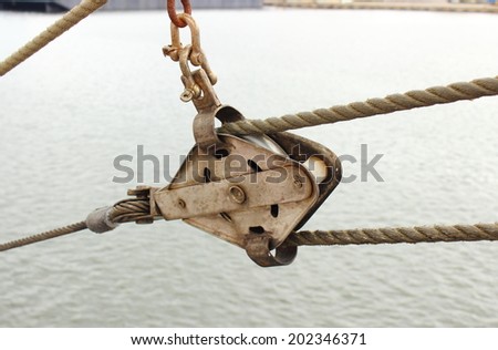 Closeup of old metal block and rigging at the yacht on sea background