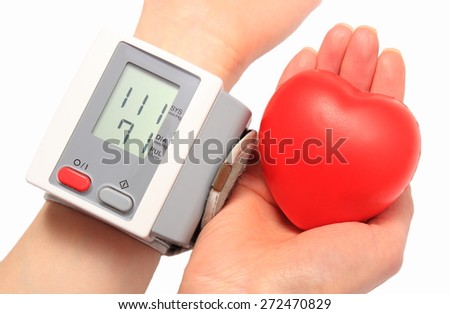 Measuring blood pressure and red heart in hand, blood pressure monitor, medicine concept