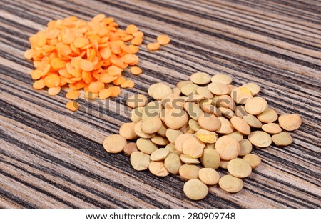 Heap of raw green and red lentil lying on wooden background, concept for healthy nutrition and eating